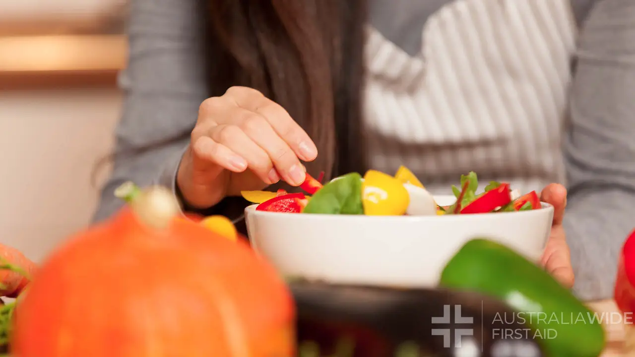 woman composing a colorful salad at home in the kitchen